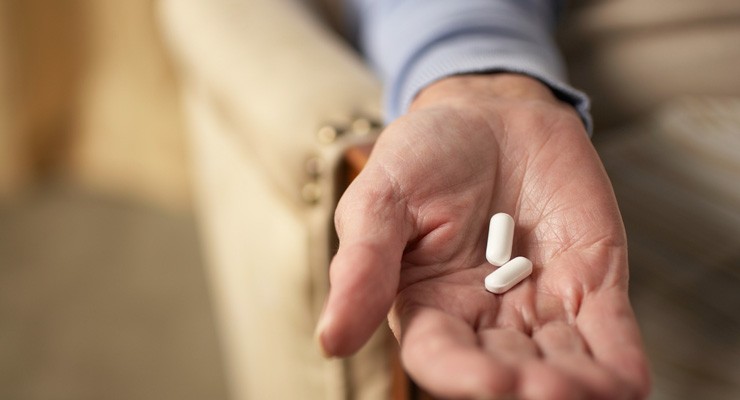 0136_Thinkstock_75627282 man's hand holding pill capsules